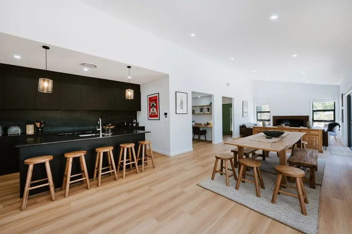 Open-plan kitchen and dining area with a long wooden table and counter seating.