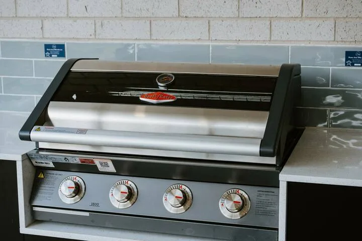 A built-in grill sits beneath a tiled backsplash.