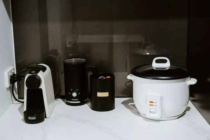 Kitchen counter with a coffee machine, canister, and rice cooker.