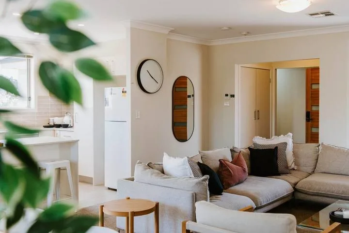 An open-plan living room and kitchen with a sectional seating area and dining counter.