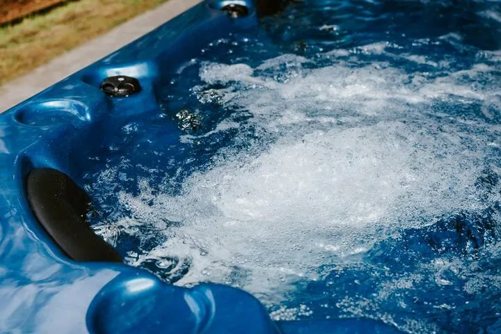 An outdoor hot tub bubbles with churning water.