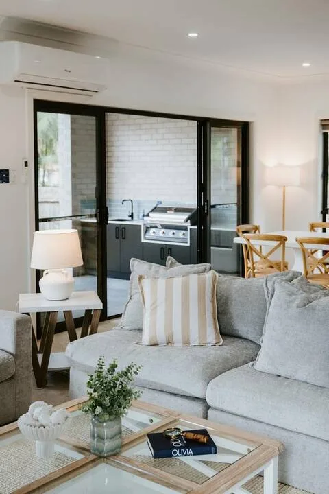 A bright living room opens onto a kitchen and dining area.
