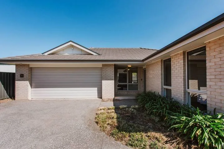 A single-story house exterior with a wide garage and paved driveway.