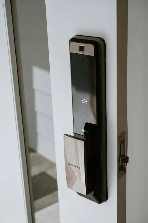 A digital keypad lock is mounted on a white door.