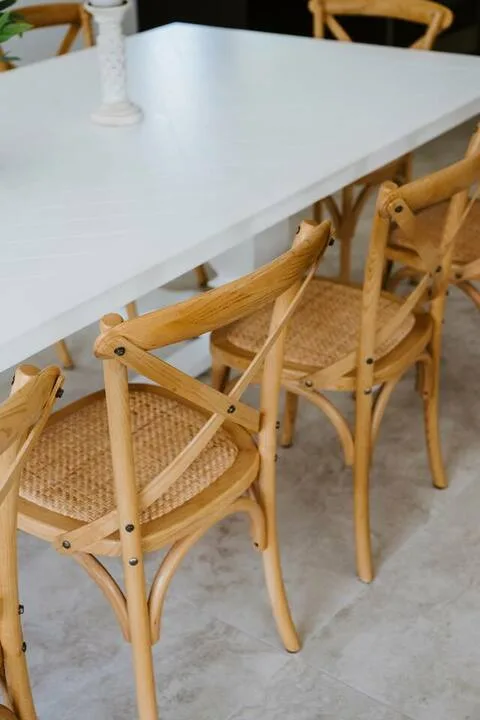 A dining table is surrounded by wooden chairs with woven seats.