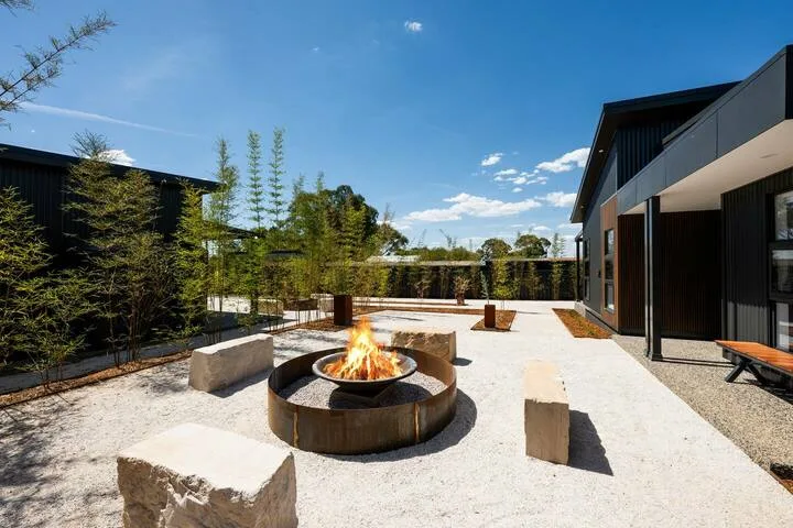 An outdoor courtyard with a circular fire pit and surrounding seating.