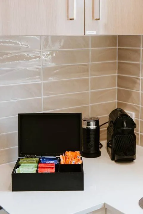 A kitchen counter with a coffee machine and an open tea box.