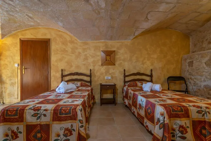 Un dormitorio con dos camas individuales y una pequeña mesa de noche.