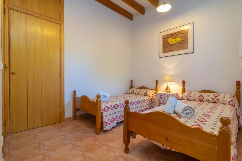 Un dormitorio con dos camas de madera cubiertas con ropa de cama estampada.