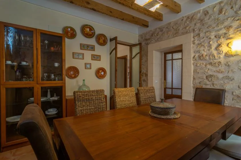 Un comedor con una mesa grande de madera y asientos tejidos.