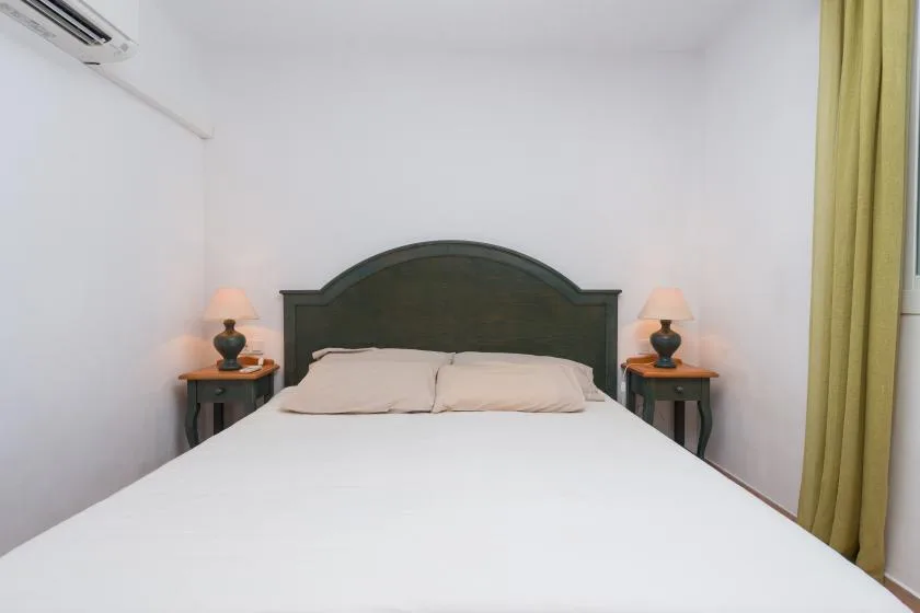 Un dormitorio con una cama grande, mesitas de noche a juego y lámparas.