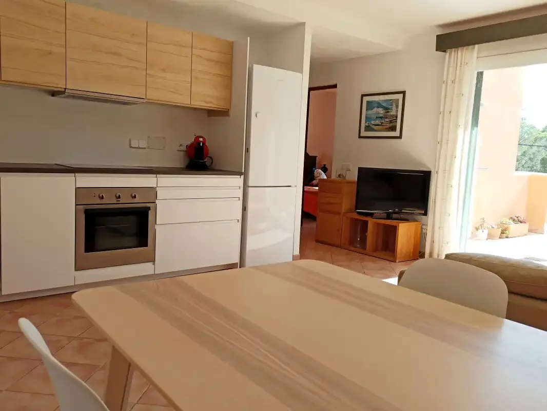 Comedor con una mesa junto a una cocina abierta y una zona de estar.