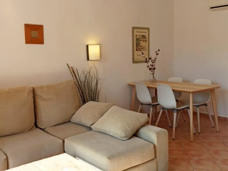 Una zona de estar y comedor con asientos, una mesa y cuadros.
