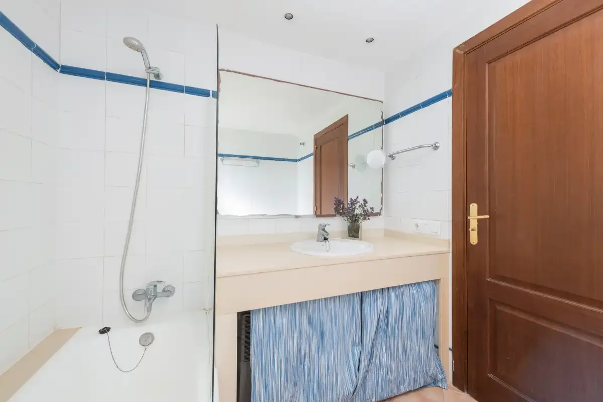 Un baño alicatado con ducha y mueble con lavabo.