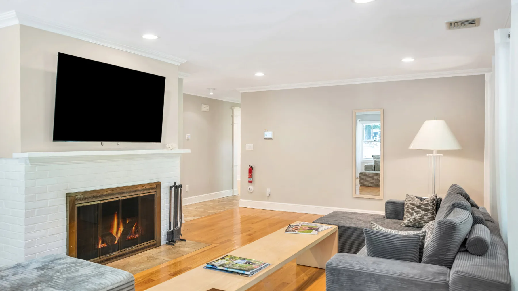 Una sala de estar con chimenea, televisor y asientos alrededor de una mesa de centro.