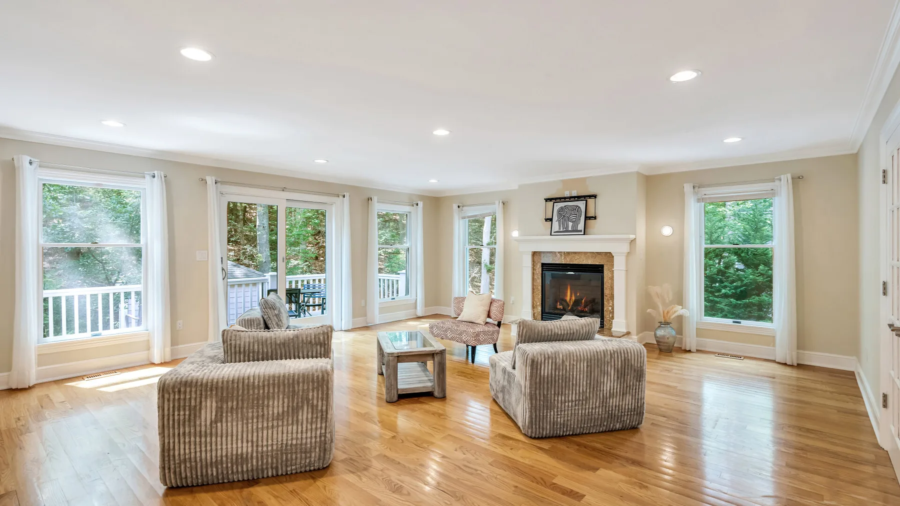 A bright living room with seating arranged around a fireplace and coffee table.