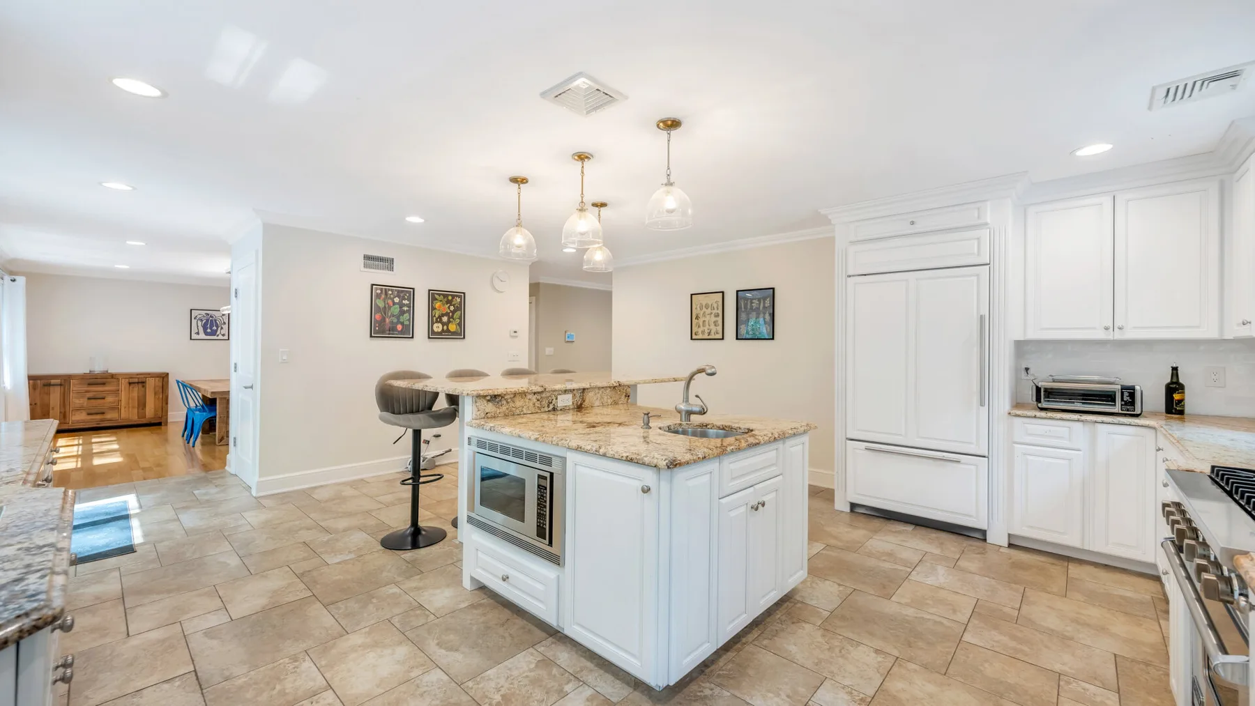 A bright kitchen with a central island and white cabinetry.
