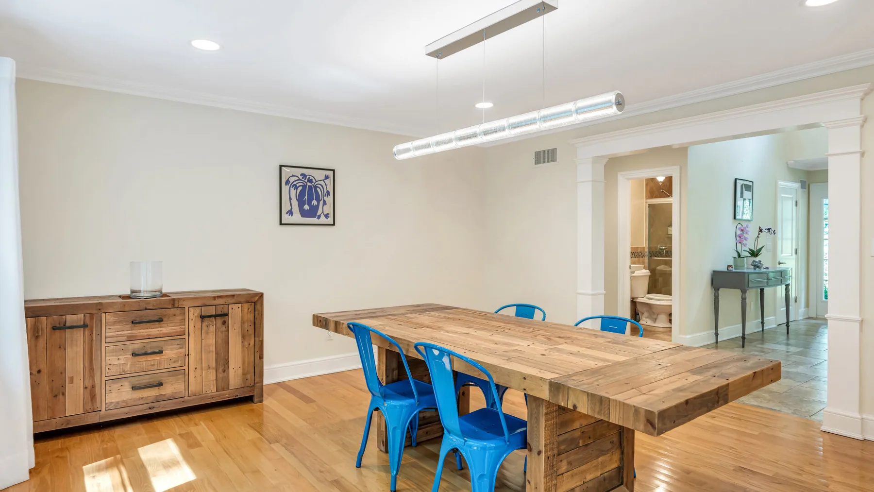 A dining area with a long wooden table and blue seating.