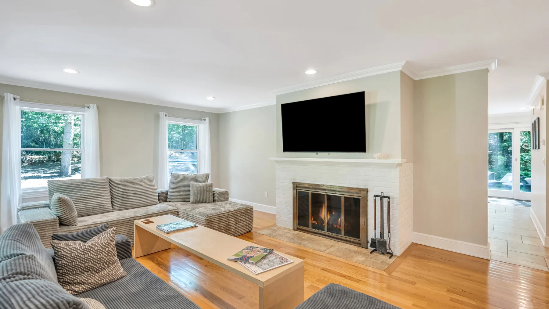 Una sala luminosa con asientos, un televisor y una chimenea.