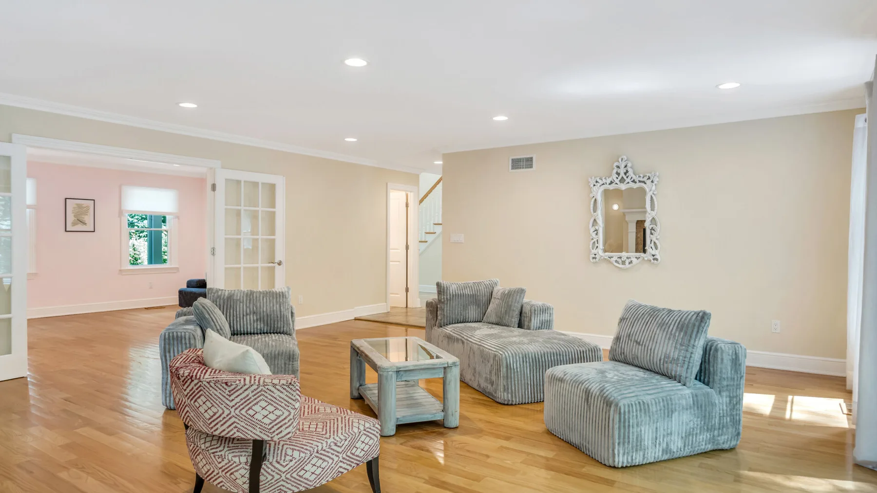 A bright living room with gray seating and a glass-topped coffee table.