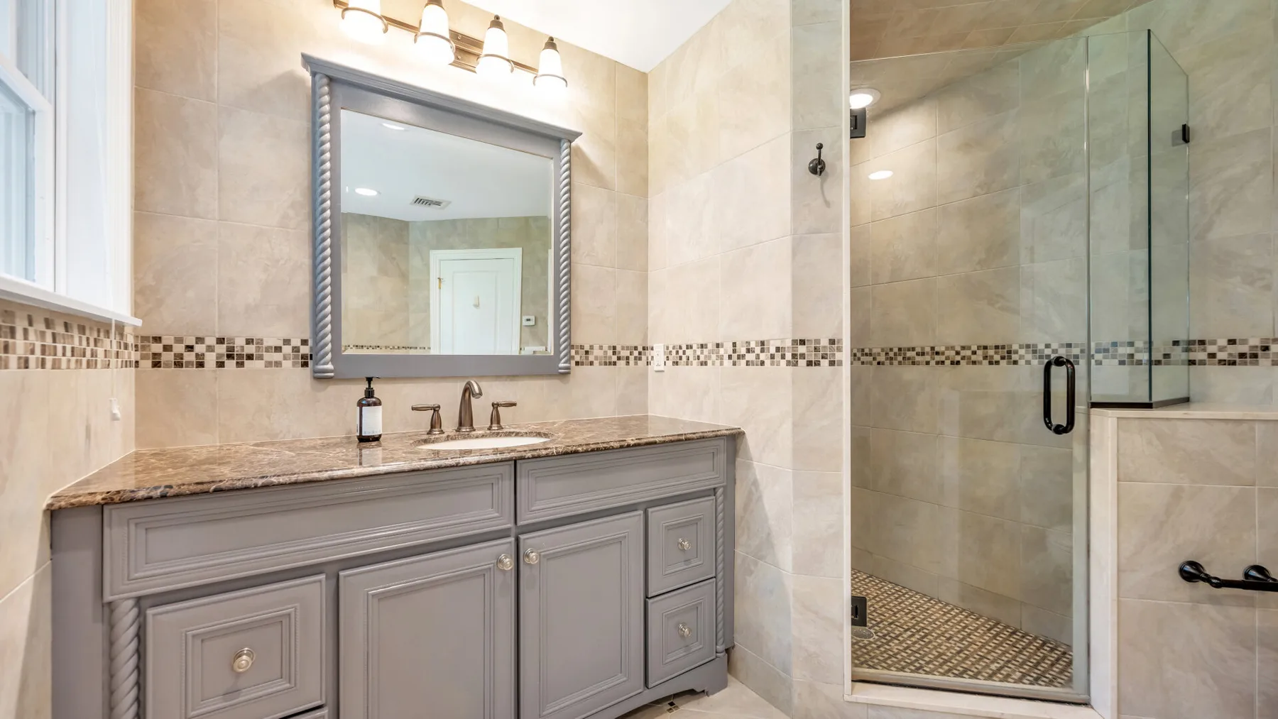 A bathroom with a vanity and a glass-enclosed shower.