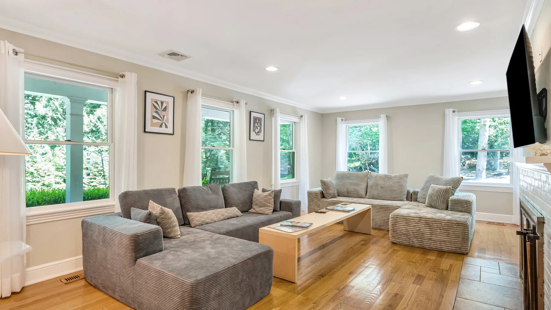 A bright living room with seating arranged around a wooden coffee table.