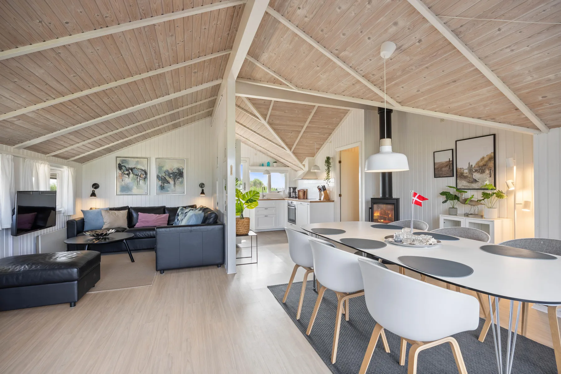Una sala de estar y comedor de concepto abierto con una mesa larga y asientos.