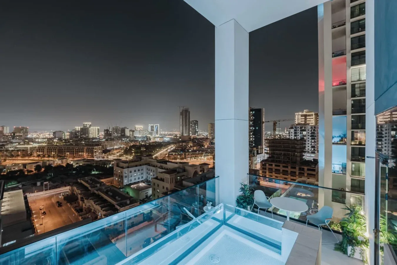 Una terraza en la azotea ofrece vistas del perfil urbano iluminado por la noche.