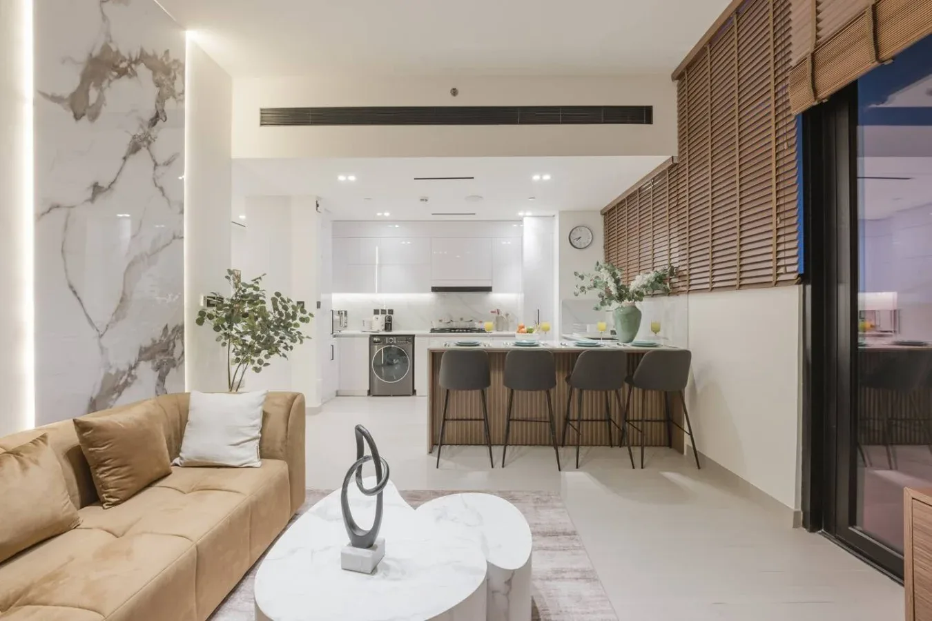 Sala de estar y cocina de concepto abierto, con sofá y barra de comedor.