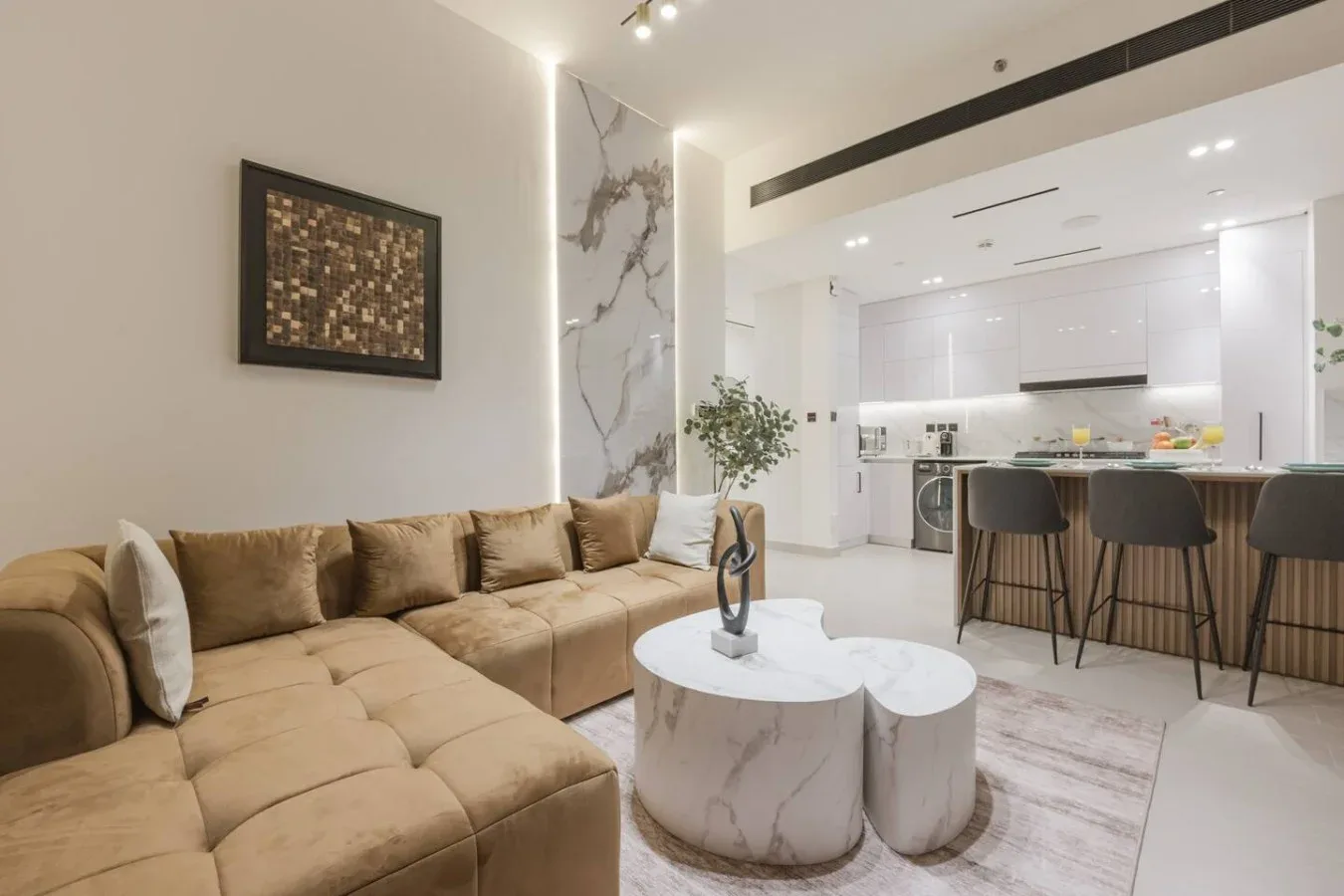 Una sala de estar moderna y abierta con zona de asientos y una isla de cocina.