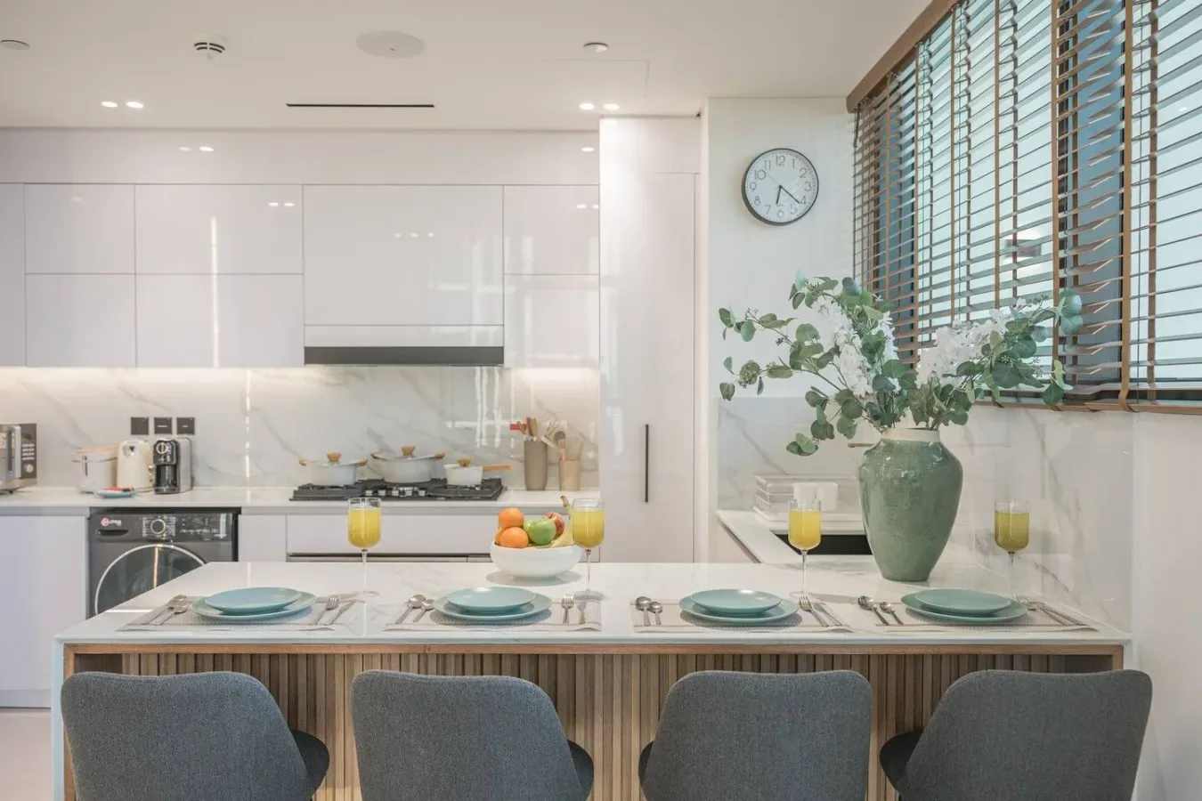 Una cocina luminosa con una barra de comedor y plantas frondosas junto a la ventana.