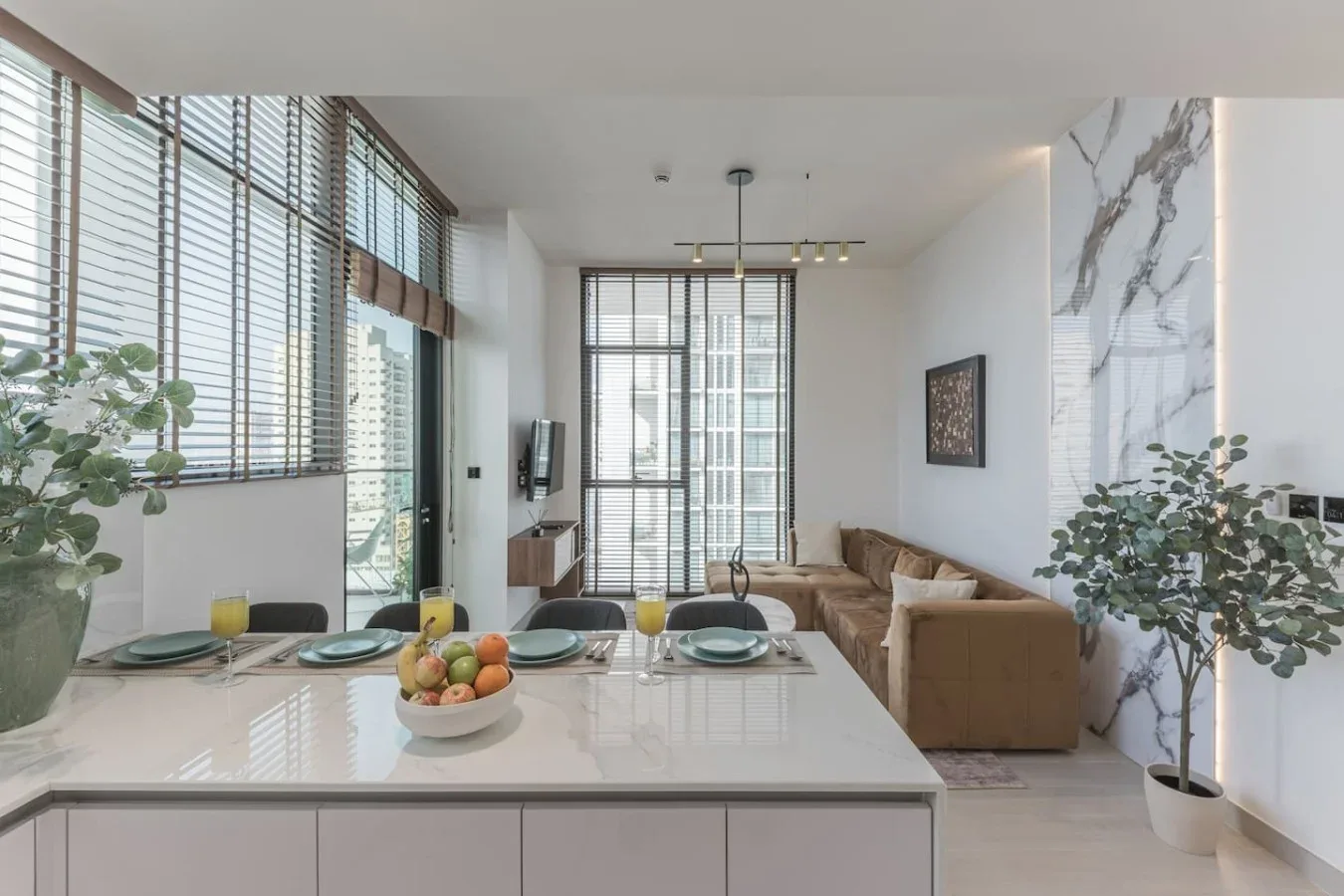 Un luminoso espacio abierto de comedor y sala de estar con grandes ventanas y una mesa de comedor.