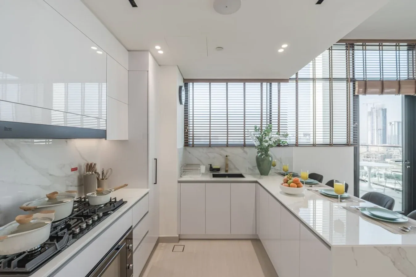 Una cocina moderna y luminosa con una estufa y una encimera preparada con comida.