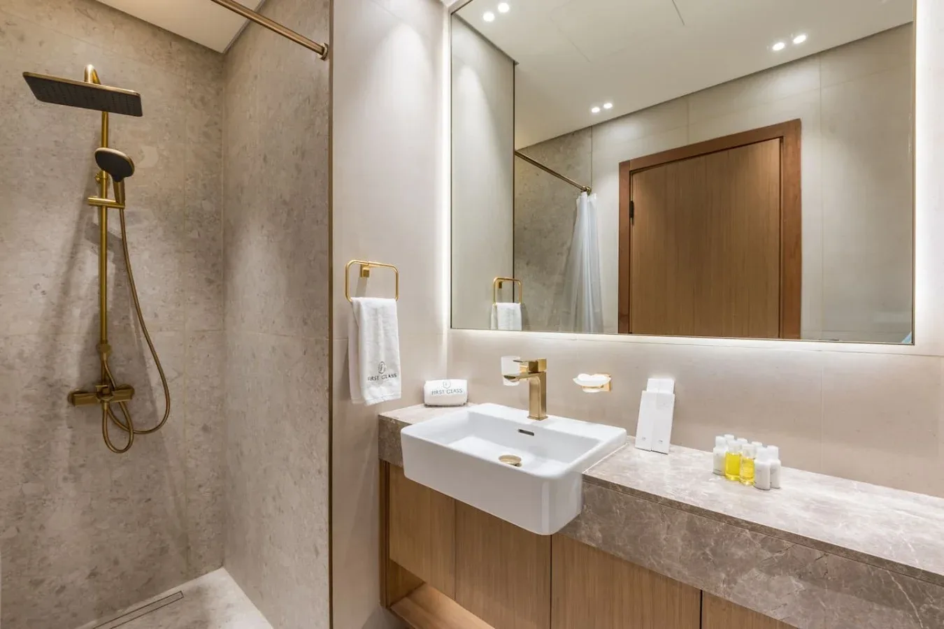 Un baño moderno con ducha, lavabo y un espejo grande.