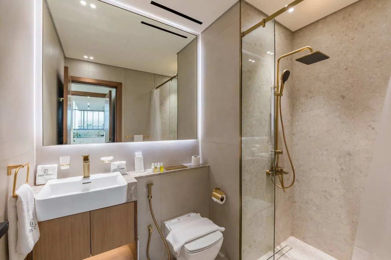 Un baño moderno con lavabo, inodoro y ducha de cristal.