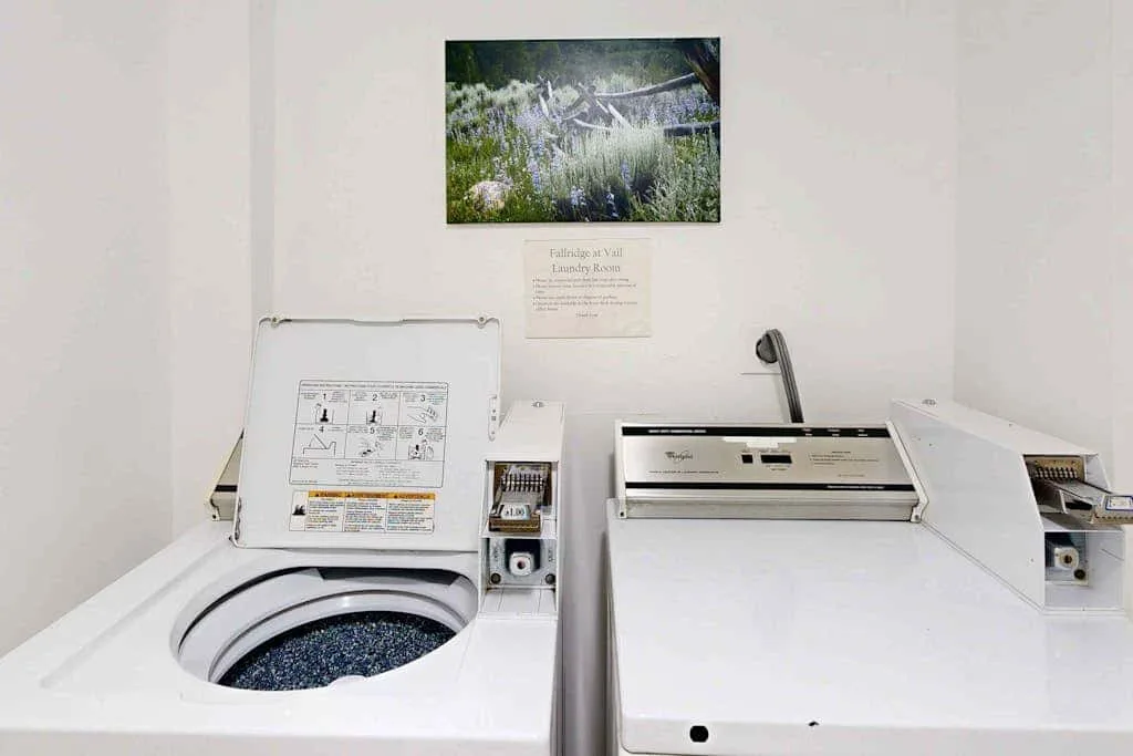 A laundry room with a front-loading washing machine and a top-loading washer.