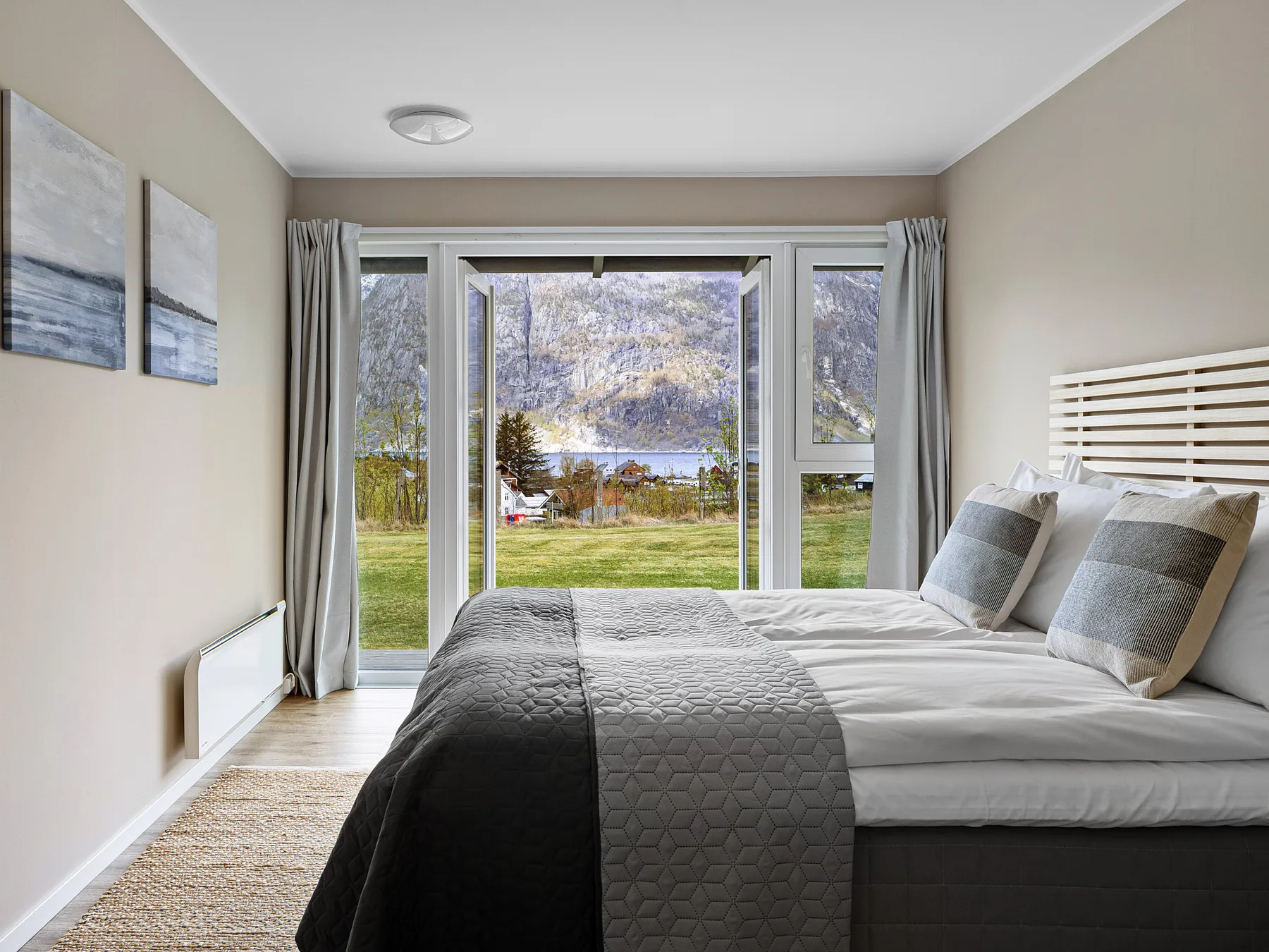 Habitación de hotel con pared de cristal y vistas al fiordo