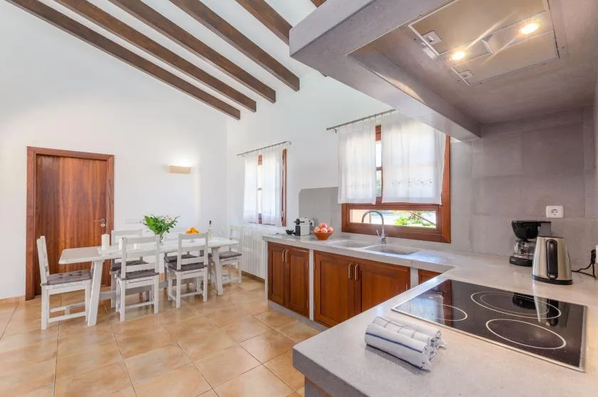 A bright kitchen and dining area with wooden cabinets and a table.