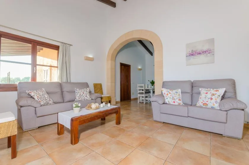 A living room with two seating areas and a wooden coffee table.