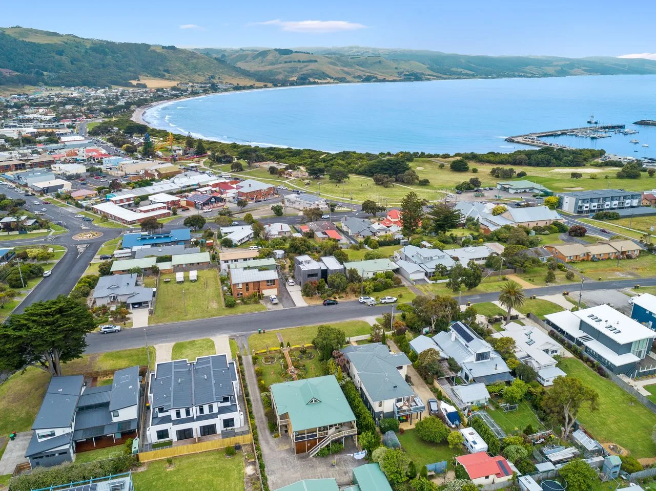 Vista aérea de un pueblo costero junto a una amplia bahía.