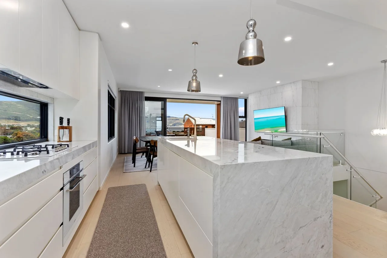 Una cocina moderna y luminosa con una isla grande y zona de comedor.