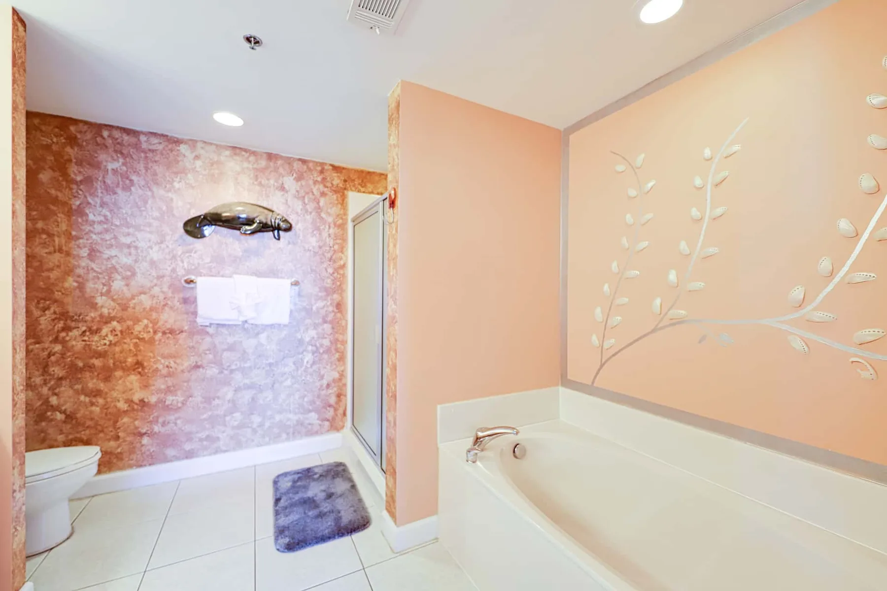 Un baño con bañera, ducha en la pared y un relieve decorativo.