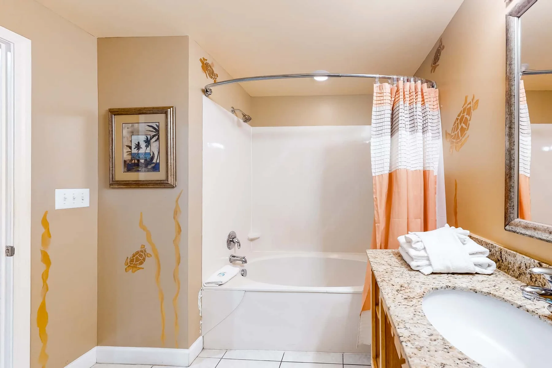 Un baño con bañera, cortina de ducha y lavabo con tocador.