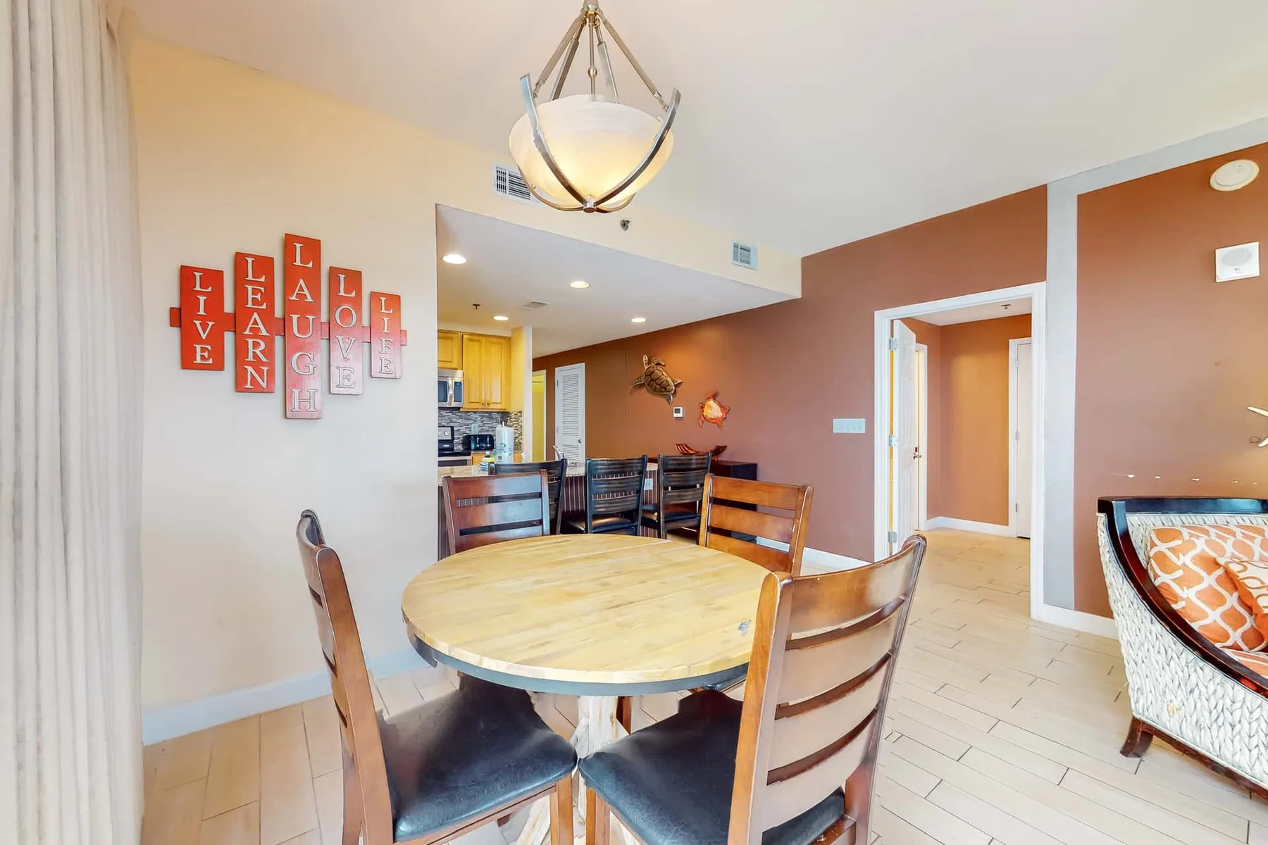 Comedor con una mesa redonda de madera y adornos en la pared.