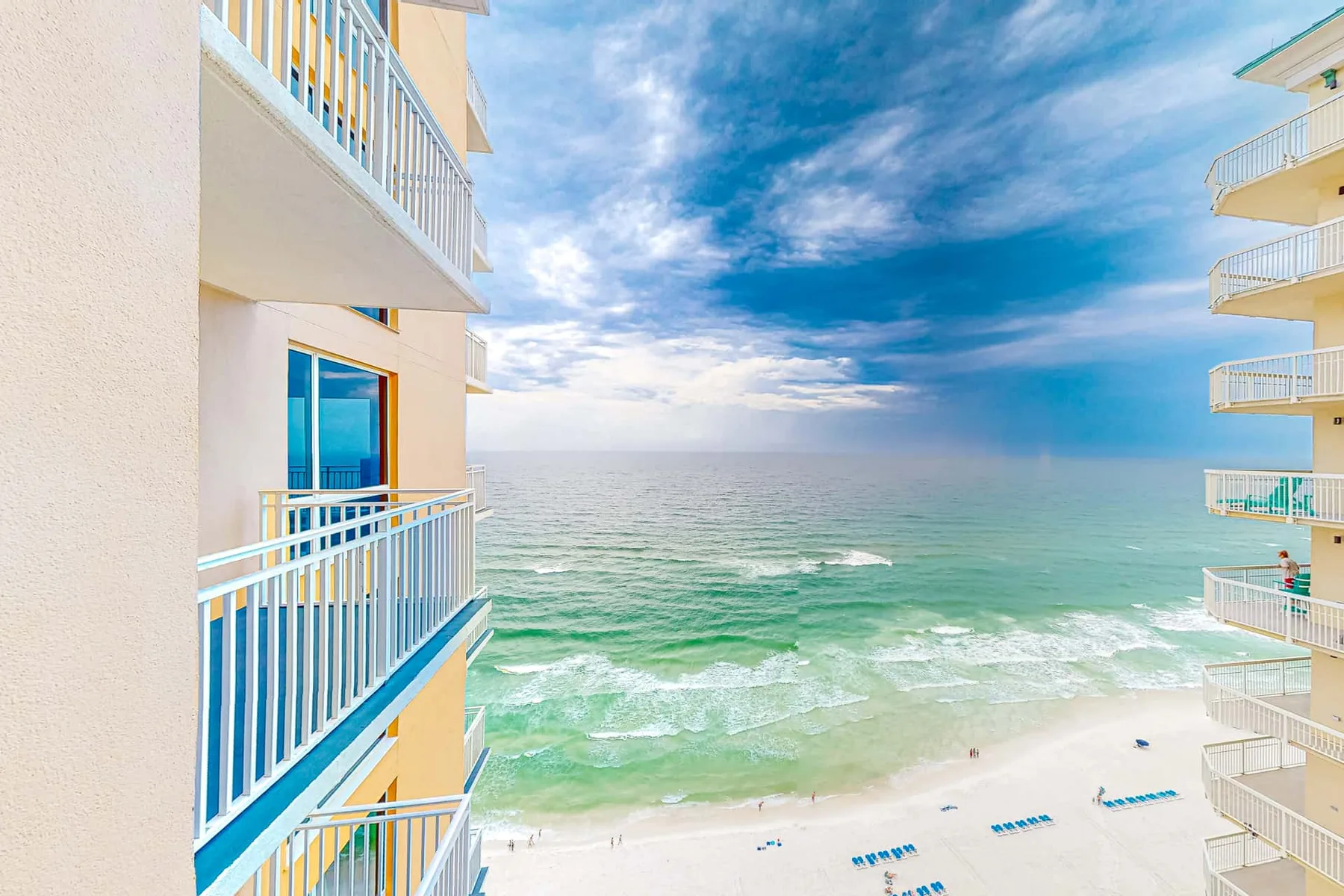 Una escena frente al mar con agua turquesa y balcones de apartamentos enmarcando la vista.