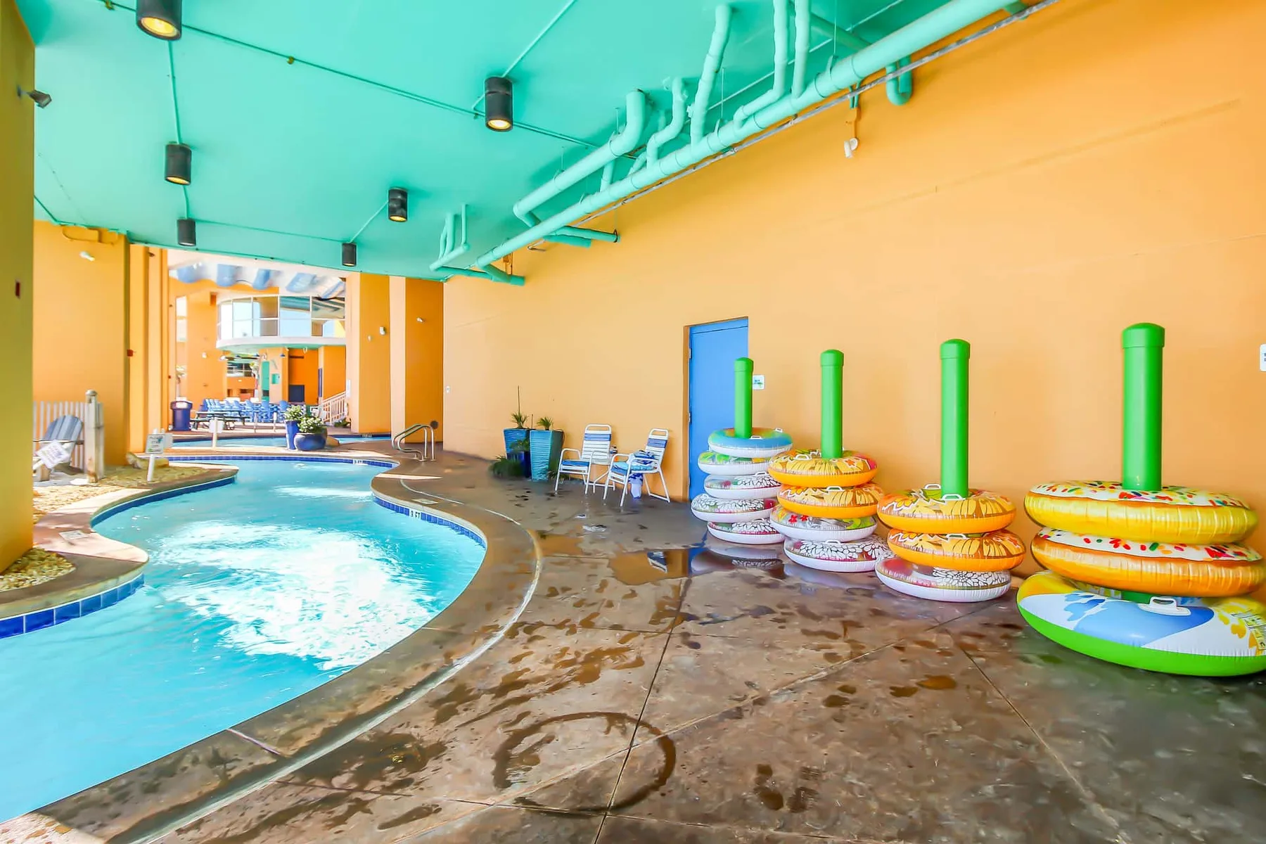 Una piscina cubierta con flotadores de colores apilados junto a la pared.