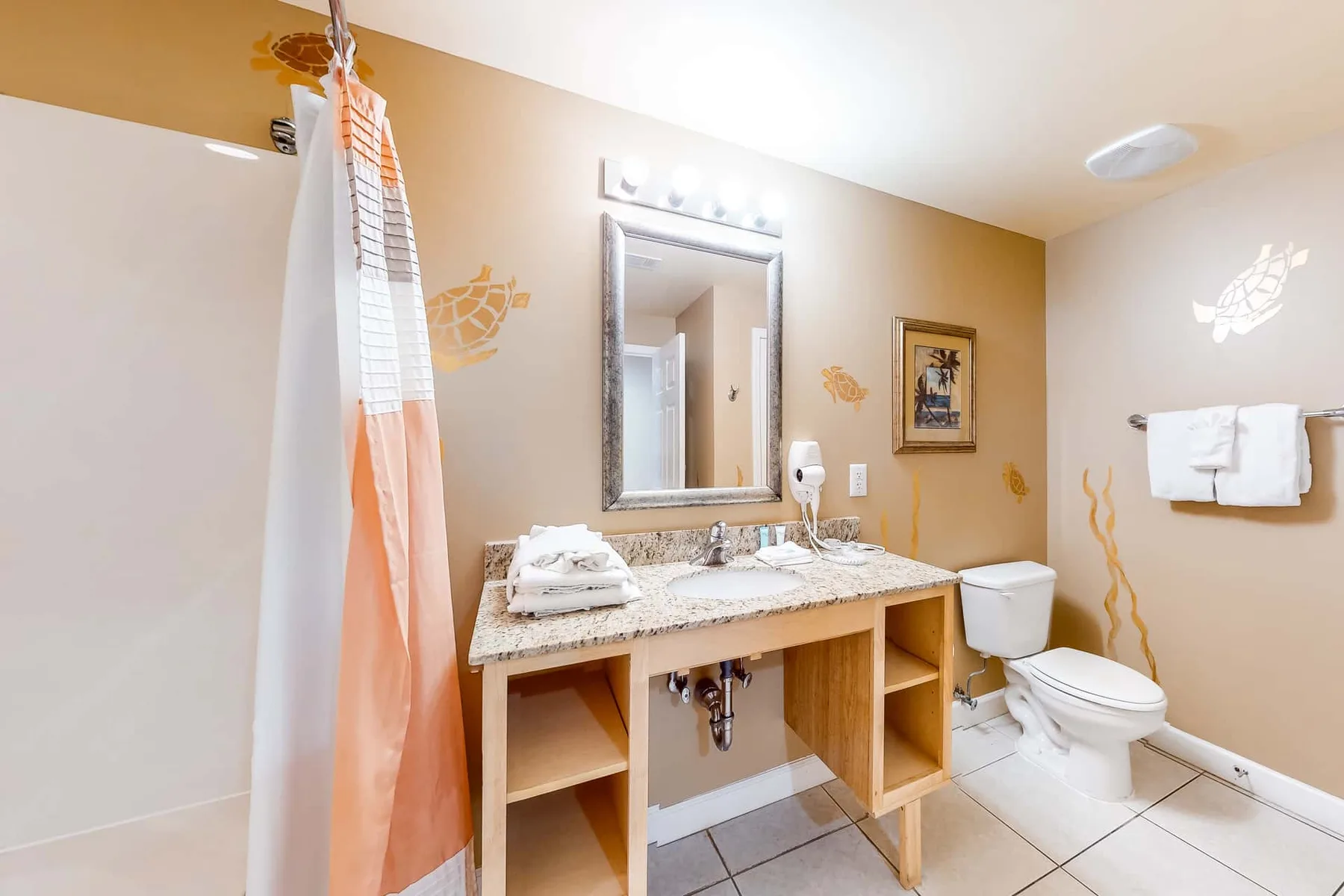 Un baño con lavabo, espejo, inodoro y cortina de ducha.