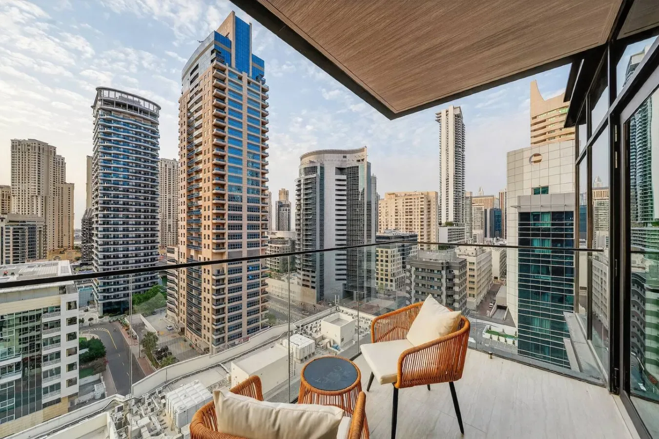 A balcony with seating overlooks a dense cluster of high-rise buildings.