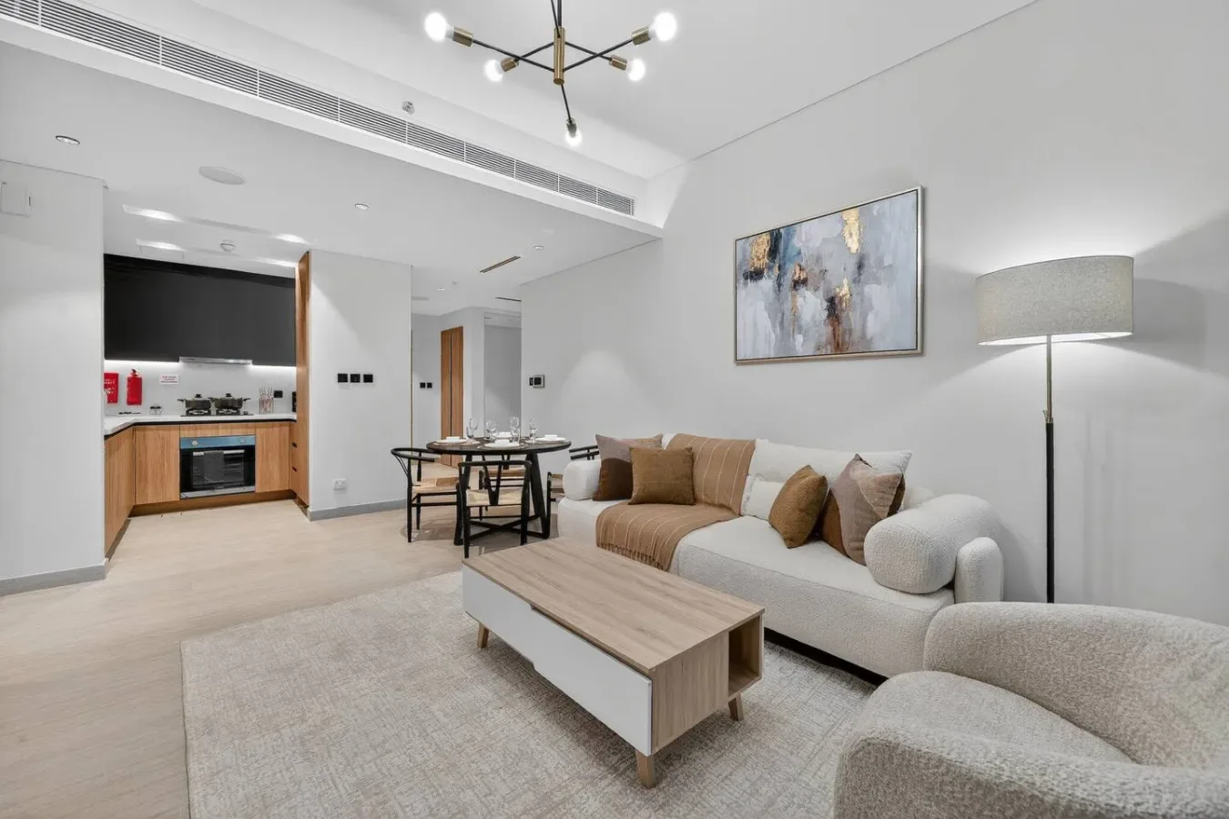 A bright living room with a sofa, coffee table, and open kitchen.