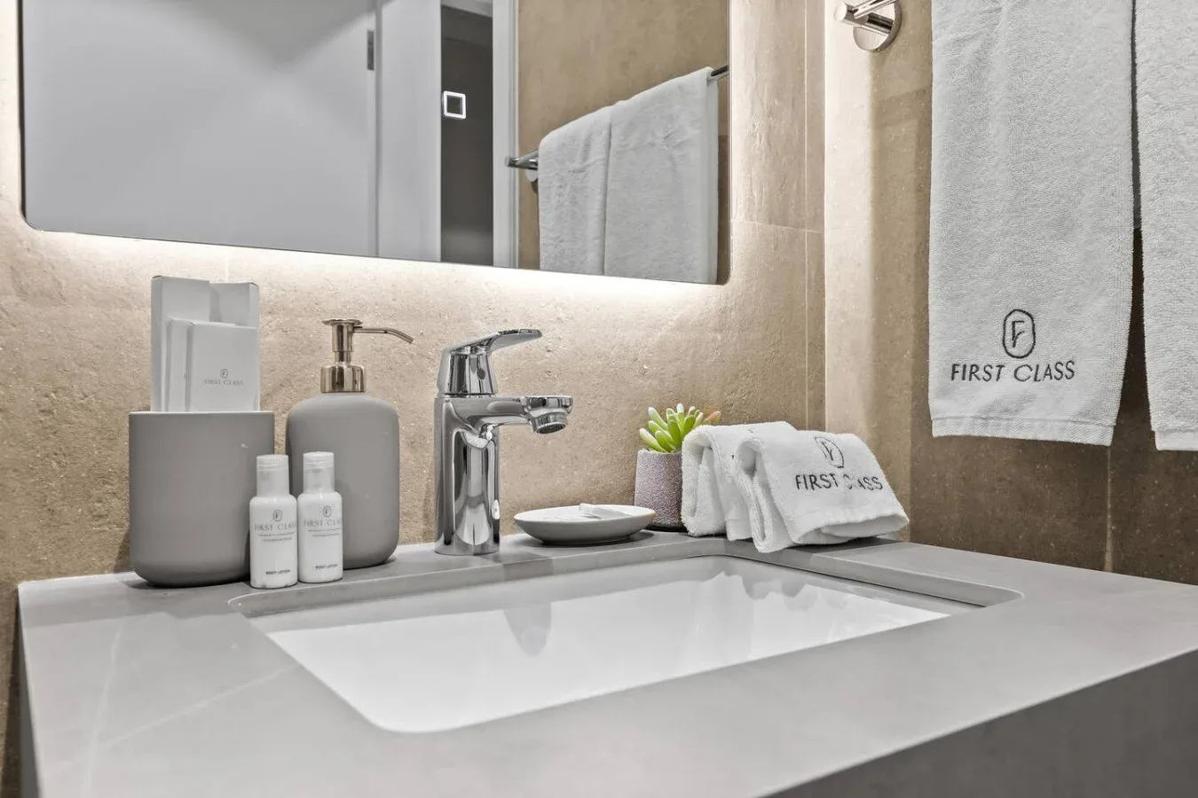 Un lavabo de baño con grifo, espejo y toallas dobladas.